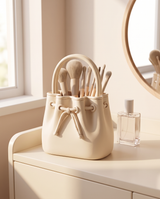 Drawstring makeup brush organiser full of brushes on a vanity beside a perfume bottle