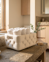 Tufted bathroom basket on a stone counter holding rolled hand towels