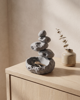 Zen stone cairn catchall holding keys on a pale oak entryway console