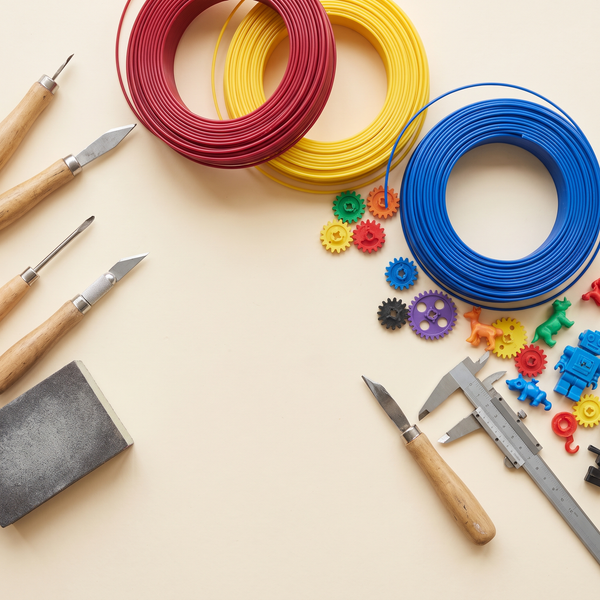 Overhead flatlay of filament spools, tools and freshly printed parts